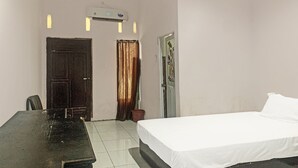 Quarto com cama, escrivaninha e ar condicionado.