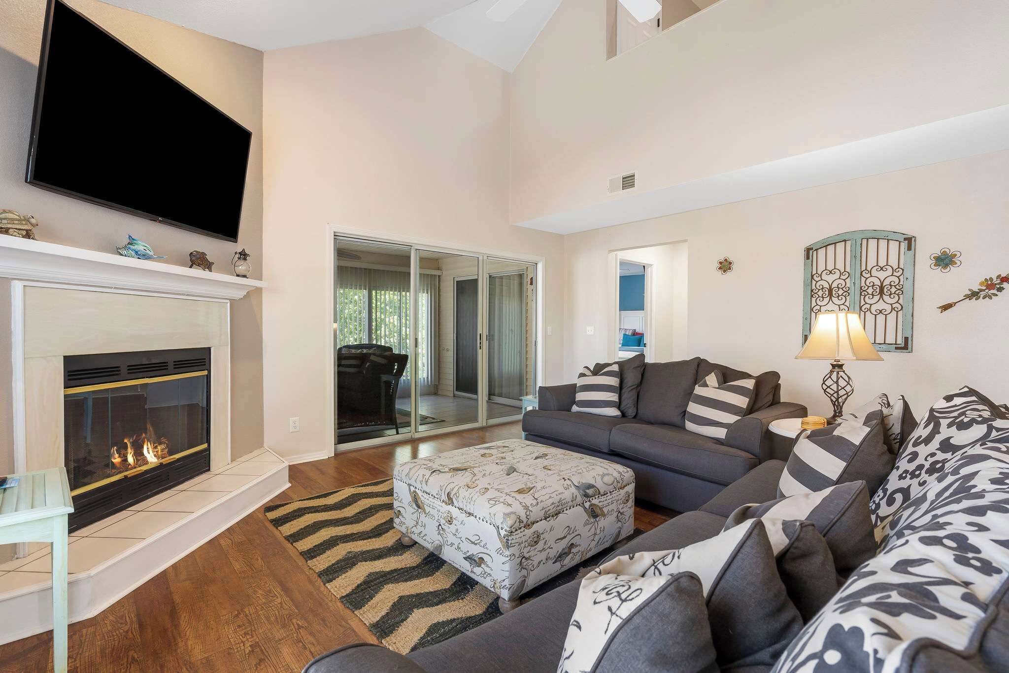 A living room with a fireplace, a sofa set, a television, and a lamp.