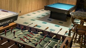 A room with a foosball table, a pool table, and a bar area. - Family Home, Blocks from Pro Football Hall of Fame, Fenced Yard, Pet Friendly (Canton)