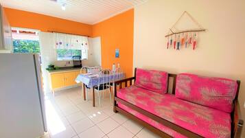 A compact living space with a kitchenette, a dining area, and a sofa.