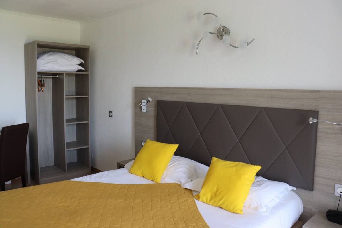 Ein Hotelzimmer mit Bett, Kleiderschrank und Nachttisch.