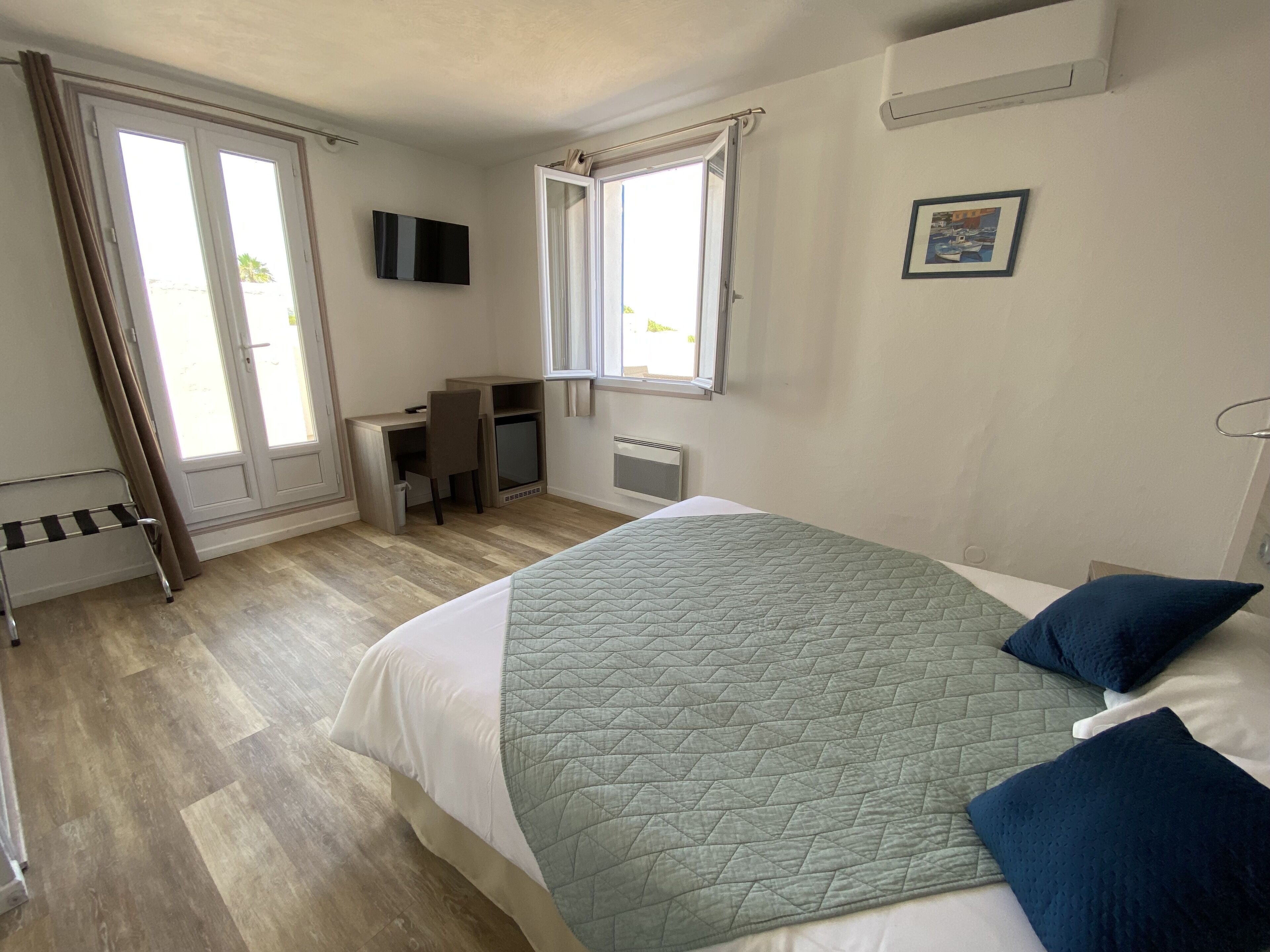 Une chambre à coucher avec un lit, un bureau, une chaise et un téléviseur.