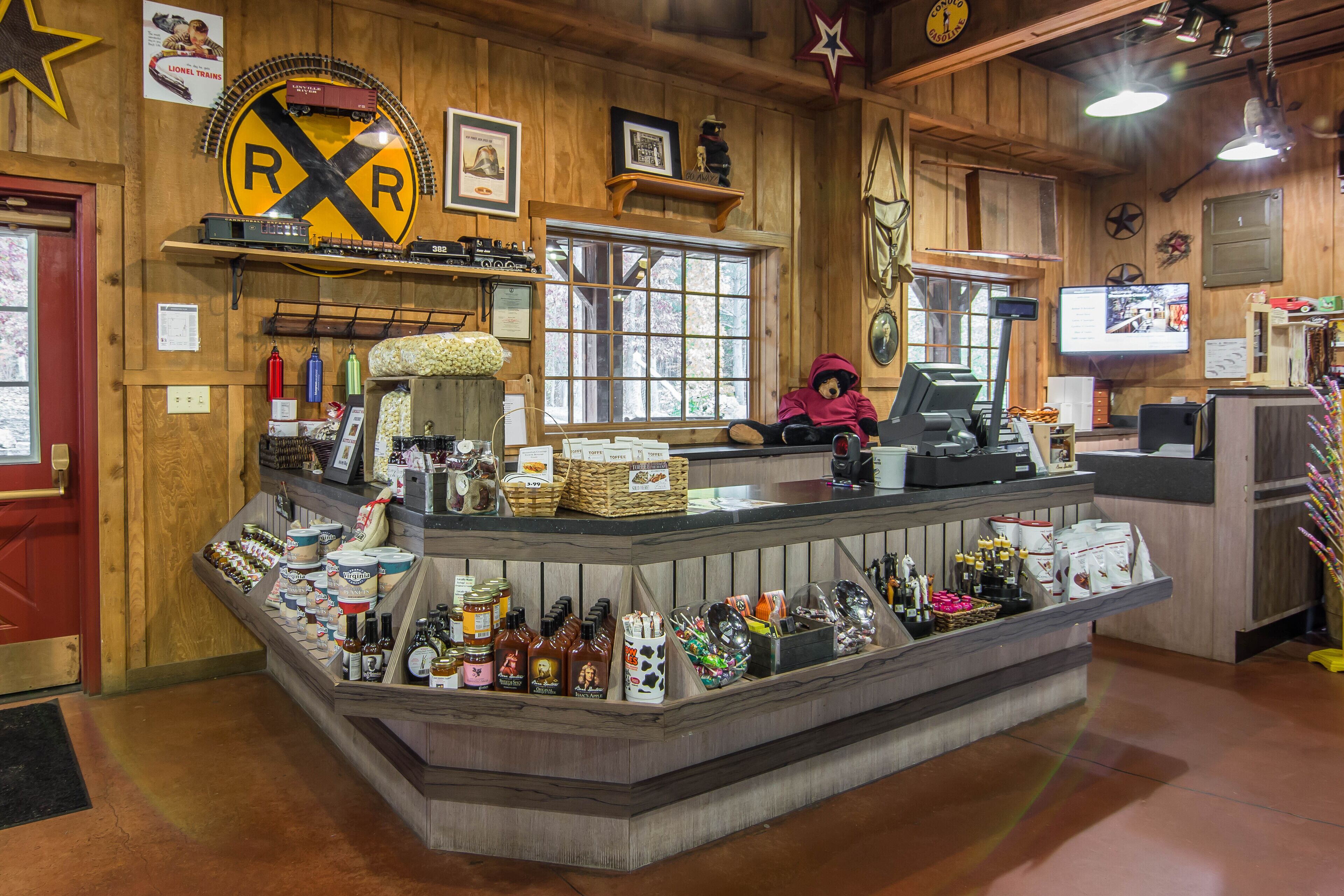 A train-themed restaurant interior with a wooden decor, a counter displaying various food items, and a teddy bear decoration.