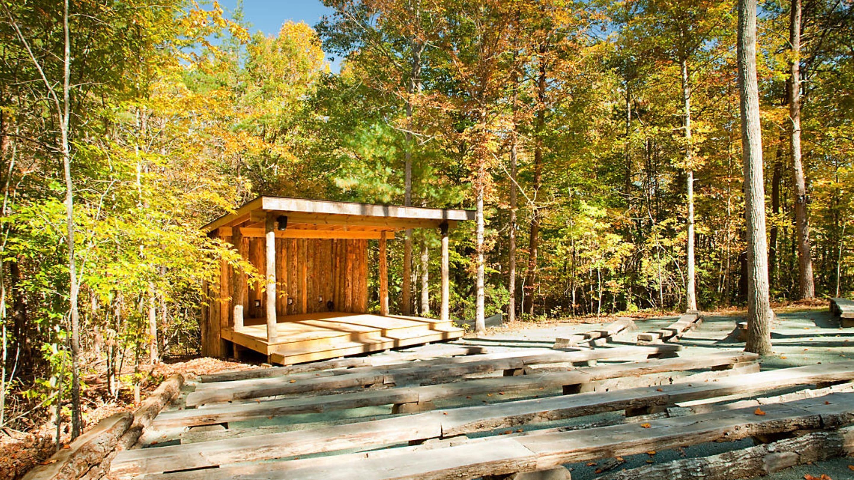 A wooden cabin with a porch in a forest.