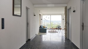 Un interior moderno con piso de mármol, un sofá y un comedor con vistas.