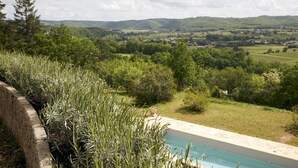 Una piscina con vistas a un paisaje exuberante y colinas lejanas.