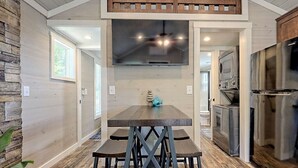 Una cocina con una isla central, un muro decorativo de piedra y electrodomésticos modernos.