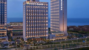 A modern hotel with a prominent 'Hyatt Place' sign, featuring a grid of windows and a central entrance.