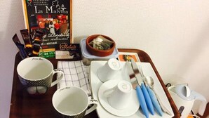 Una bandeja con un libro, tazas de café, un bol y una tetera.