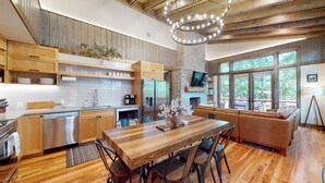 A modern kitchen with wooden cabinets, a built-in oven, and a large island with seating. - Private Hot tub, 1mi to Shangri La, next to Battlefield Par 3, & Walk to Lake (Afton)