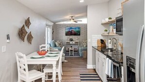 A modern kitchen with white cabinetry, a black countertop, and a built-in microwave. - Comfortable , newly remodeled, close to Siesta Key (Sarasota)