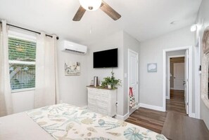 Cozy retreat with a flat-screen TV, comfortable bed, and a dresser with mirror.