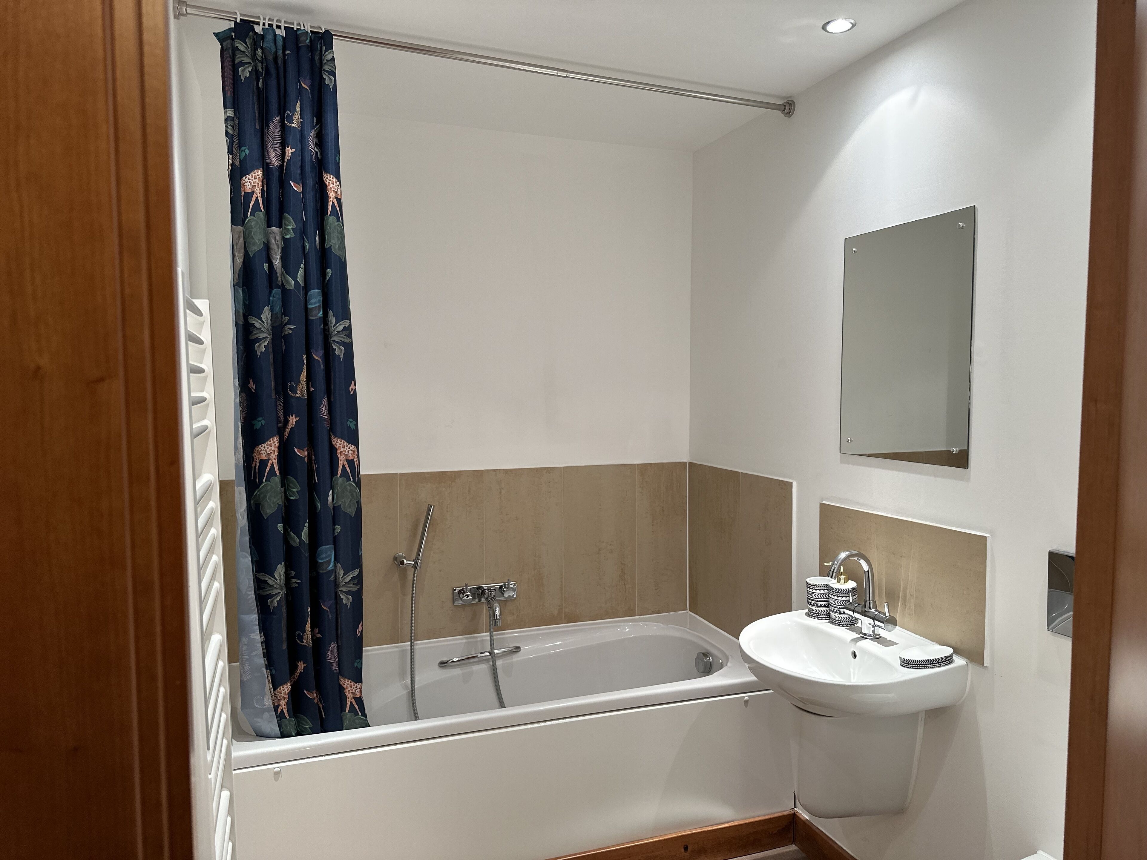 Een moderne badkamer met een bad, een wastafel en een spiegel.