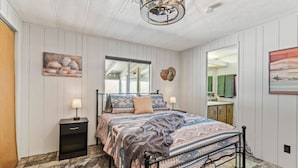 A bedroom with a bed, bedside tables, a window, and a mirror. - Cosy Desert Hideaway (Tucson)
