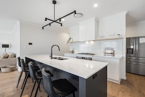 A modern kitchen with a central island, stainless steel appliances, and a minimalist design.