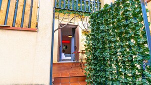 A narrow stairway leading to a room with a bed and a table, surrounded by a green ivy-covered wall and a wooden fence. - Art House Arenella con Terrazze by Wonderful Italy (Palermo)