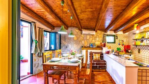 A rustic kitchen with wooden beams, stone walls, and a tiled floor. - Art House Arenella con Terrazze by Wonderful Italy (Palermo)
