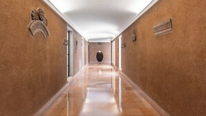 A long, polished hallway with a high ceiling and walls adorned with decorative plaques. - Design Suite in Bologna by Wonderful Italy (Bologna)