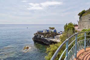 A coastal view with a rocky outcrop, clear blue sea, and a small boat. - Eden Vista Mare con Piscina by Wonderful Italy  (Genoa)