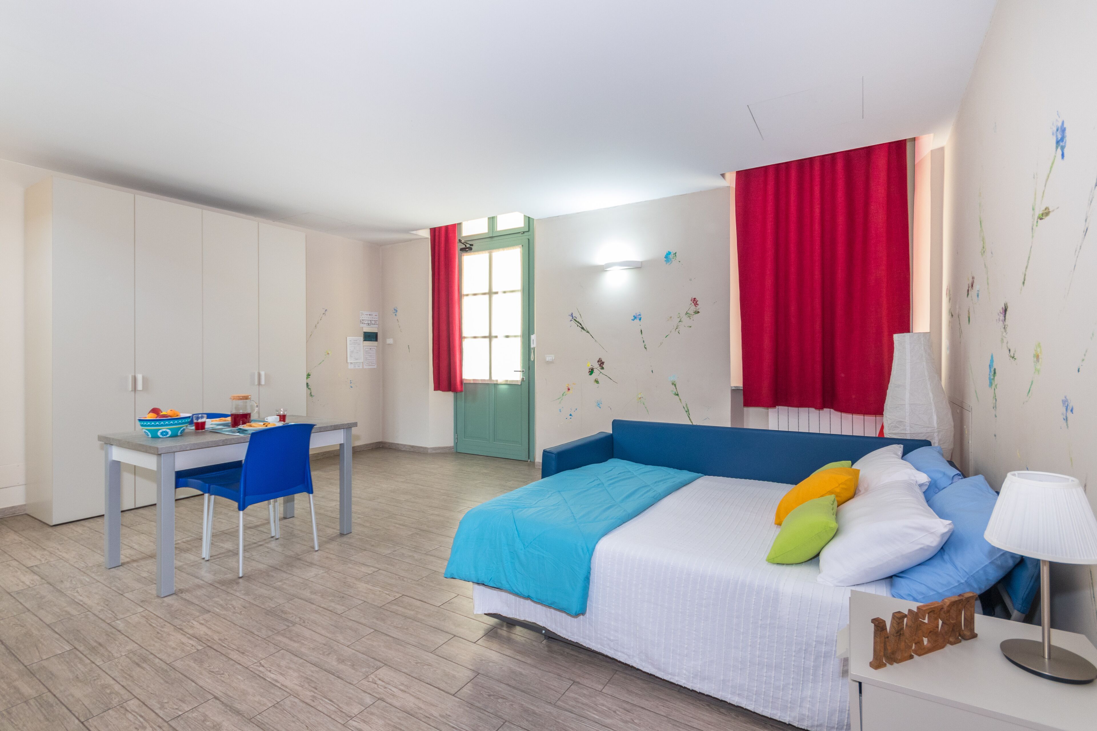 A bedroom with a bed, a desk, and a chair.