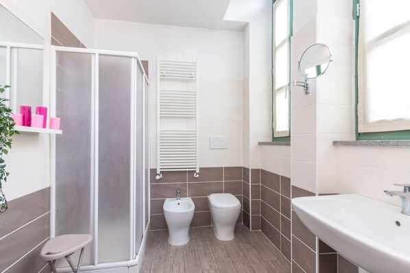 Une salle de bain équipée d’une douche, d’un bidet, de toilettes et d’un lavabo.