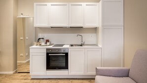 A compact kitchen with white cabinetry, a built-in oven, and a sink. - Maison Del Reno By Wonderful Italy (Bologna)