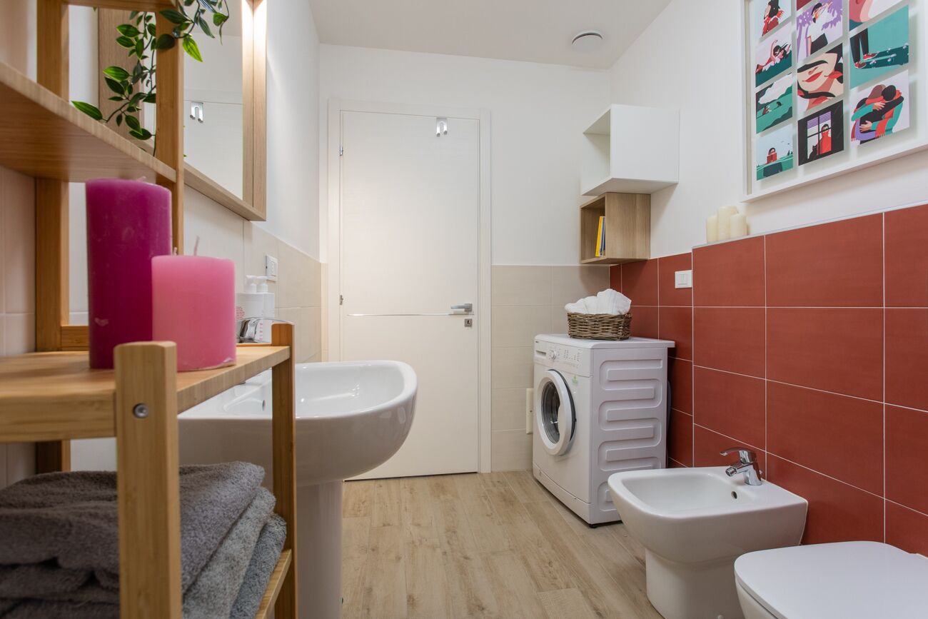 Ein kleines Badezimmer mit Waschbecken, Bidet und Waschmaschine.
