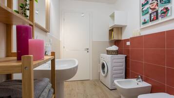 Ein kleines Badezimmer mit Waschbecken, Bidet und Waschmaschine.