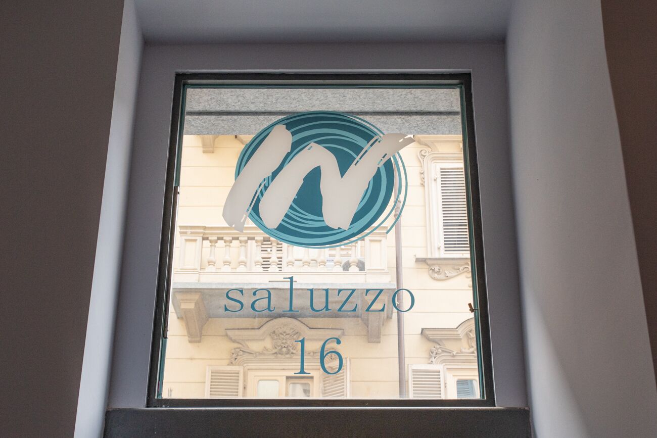 Ett fönster med en logotyp och texten ”saluzzo 16”.