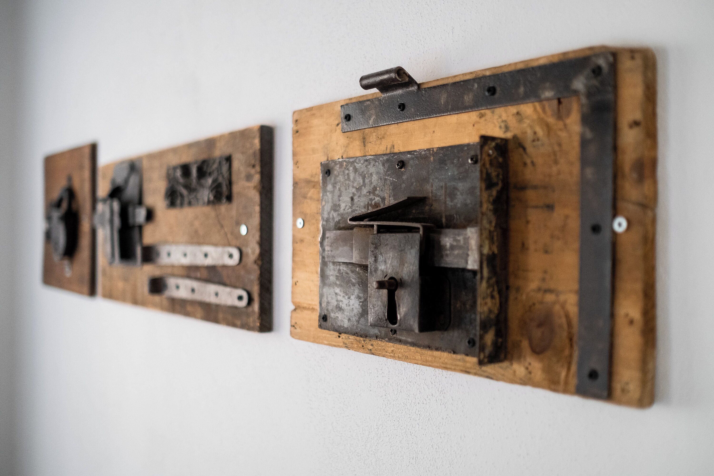 Two wall-mounted objects with metal and wooden components, possibly electrical switches or fixtures.