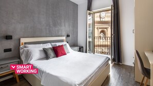 A modern bedroom with a large bed, a desk, and a balcony with a wrought iron railing. - Villena Plaza by Wonderful Italy (Palermo)