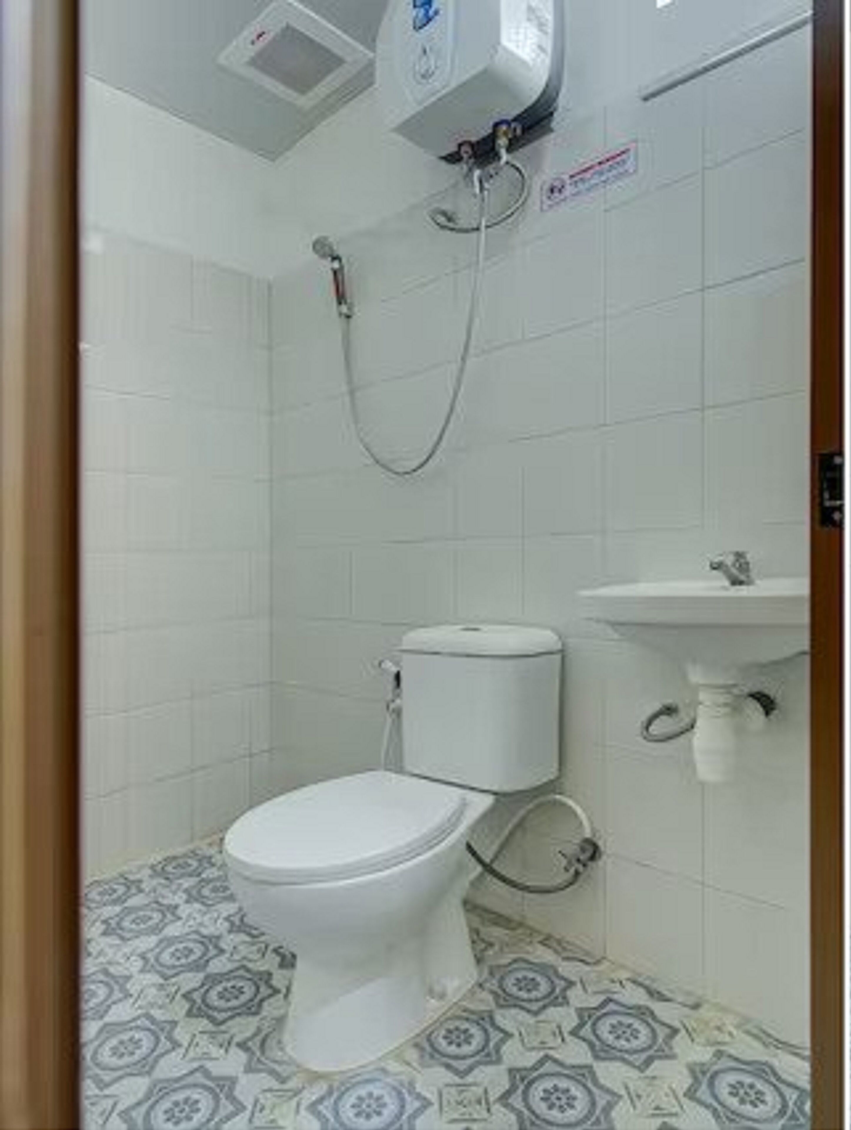 A small bathroom with a toilet, a sink, and a shower.