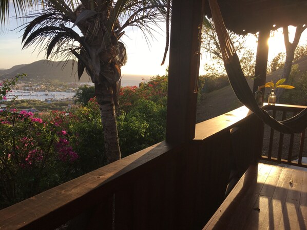 A wooden deck with a view of a harbor and mountains.