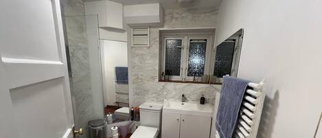 Ein kleines Badezimmer mit Toilette, Waschbecken und Dusche.