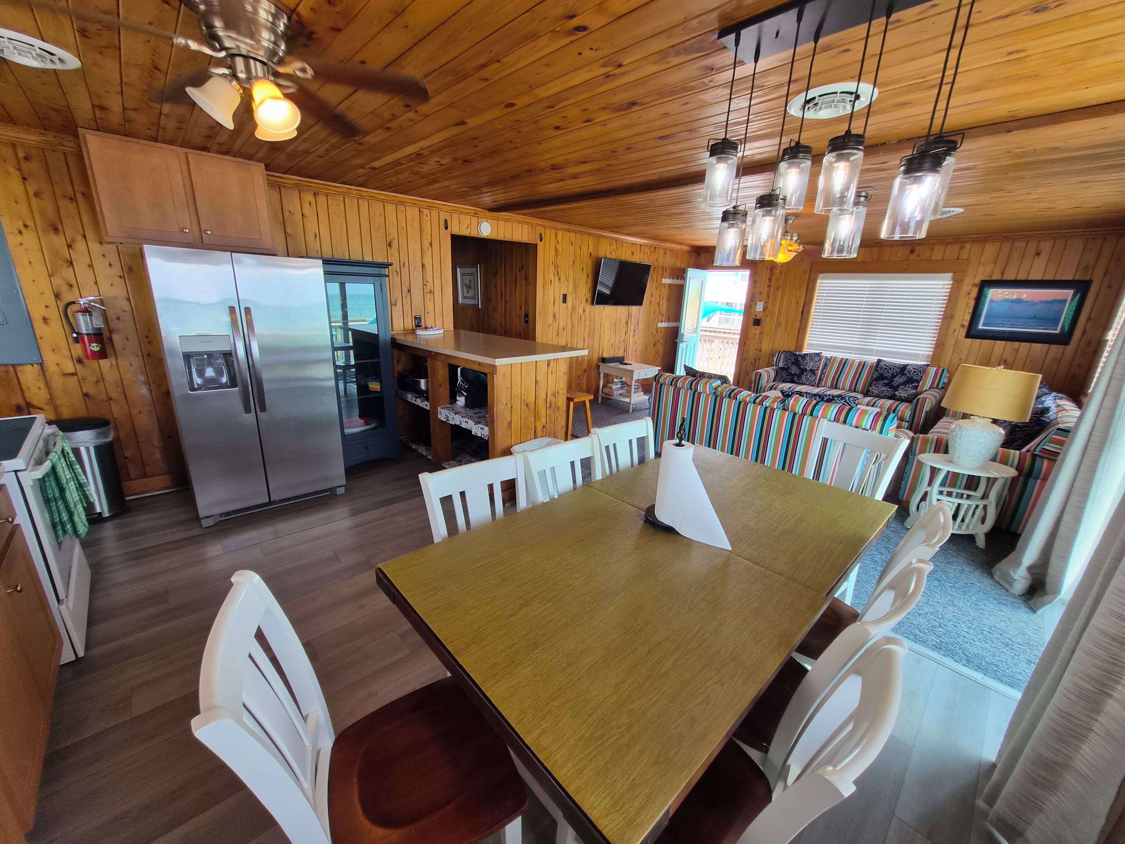 A wooden interior with a dining area, kitchen, and seating.