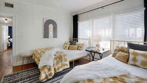 A bedroom with a bed, a bedside table, a lamp, and a window with blinds. - Kayak from your backyard (Bradenton)