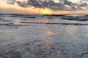 Enjoy a serene beach experience with gentle waves lapping onto the shore.