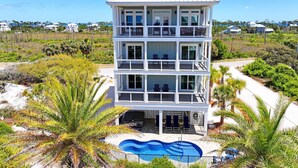 A multi-story building with balconies, a swimming pool, and a view of the surrounding landscape. - The Barracuda - Cape San Blas (Port Saint Joe)