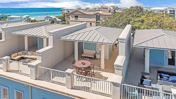 A residential area with multiple houses, a balcony with outdoor furniture, and a view of the ocean. - 30A, 300ft to beach, pool, pingpong, foosball, GulfPlace, ocean views! (Santa Rosa Beach)