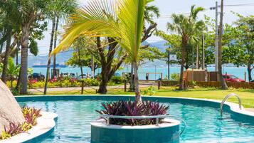 Alberca al aire libre, sombrillas en la alberca y camastros