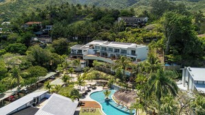 Un resort con piscina, varias edificaciones y abundante vegetación.