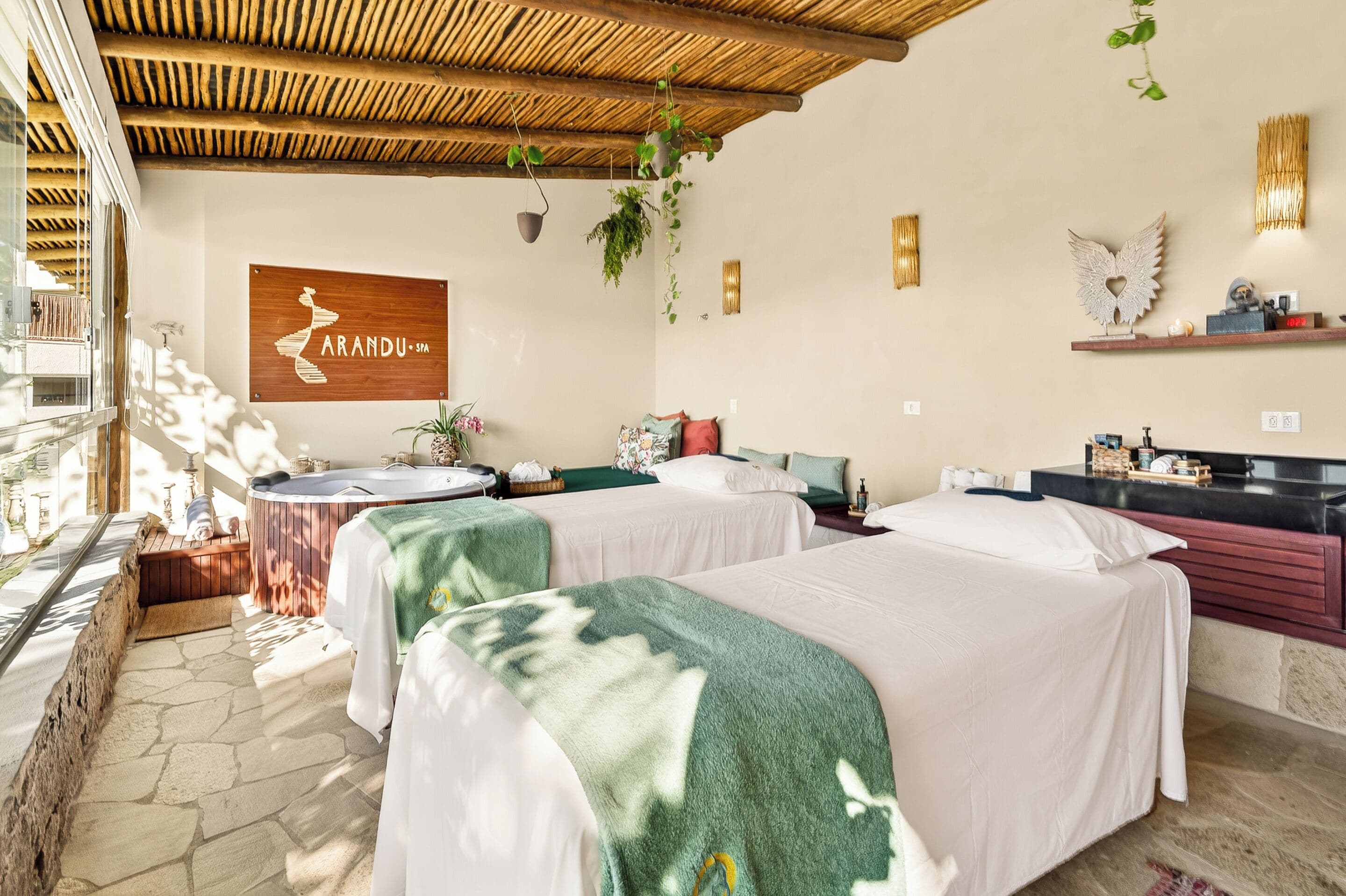 A hotel room with two beds, a wooden ceiling, a wall-mounted sign, and a small balcony.