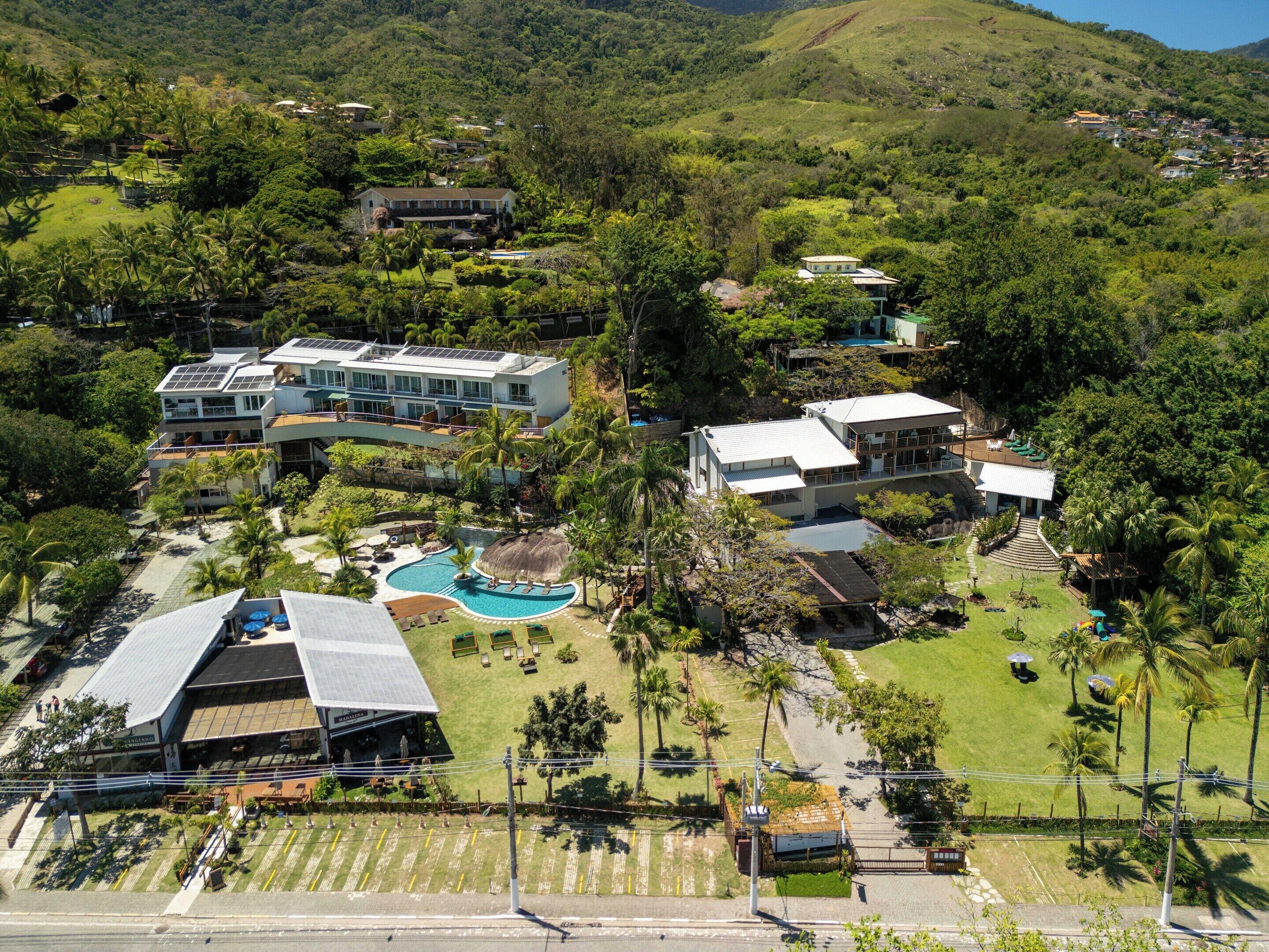 Ein Resort mit mehreren Gebäuden, einem Pool und üppiger Bepflanzung.