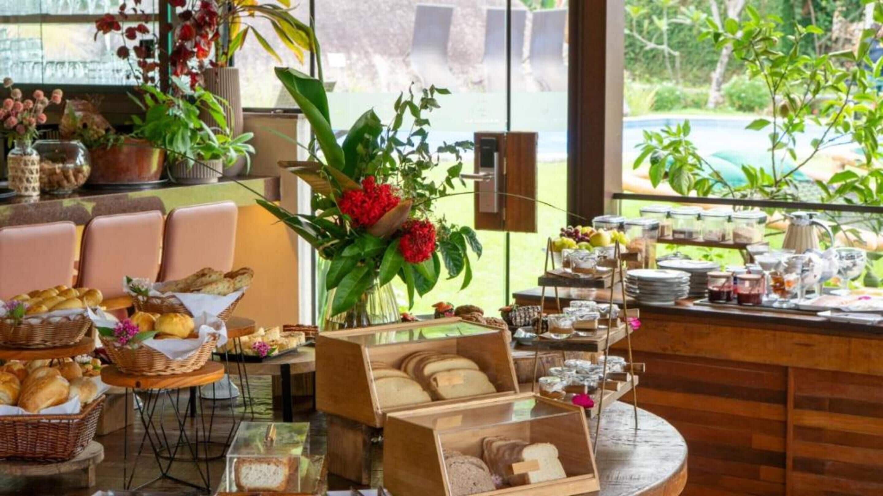 A breakfast buffet with bread, pastries, and fruits.