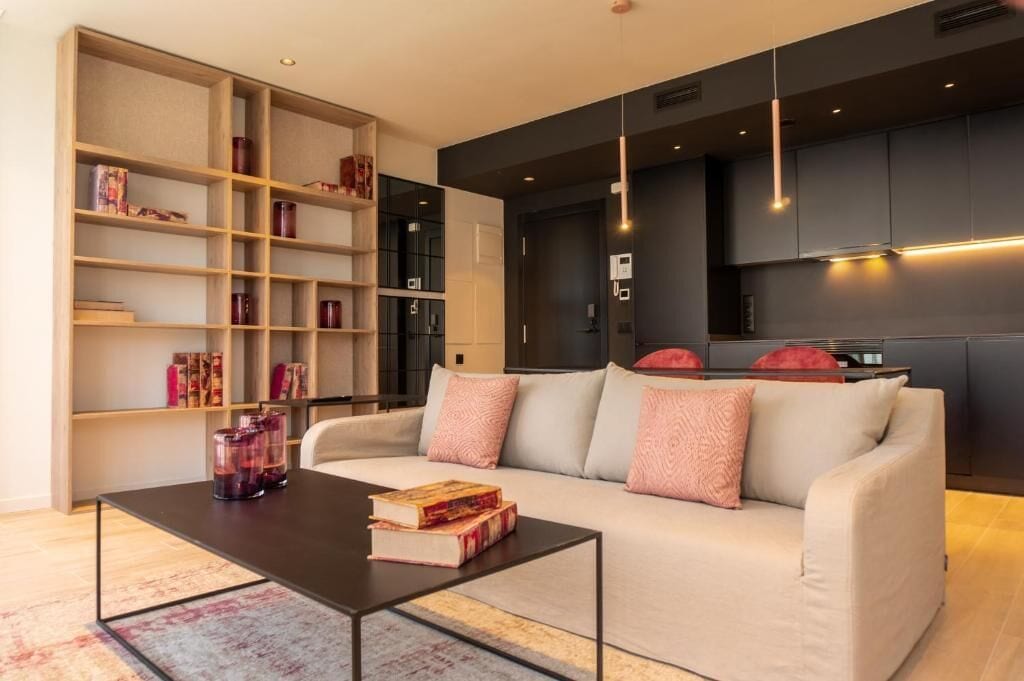 A modern living room with a sofa, coffee table, and bookshelf.