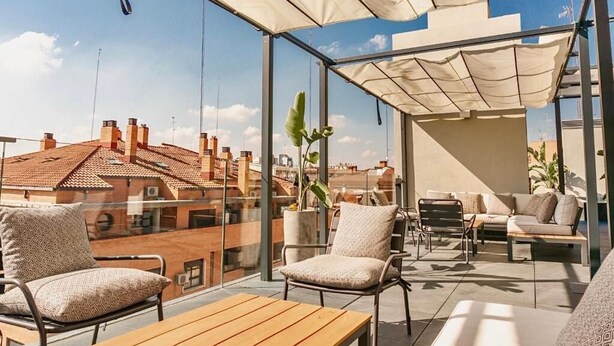 A rooftop terrace with a glass balustrade, outdoor seating, and a view of the cityscape. - Valencia Luxury - Sea Port II (Valencia)