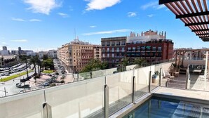 A rooftop pool with a glass balustrade overlooking a cityscape. - Valencia Luxury - Calma Beach Apartments (Valencia)