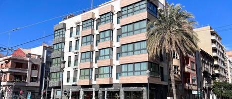 Um hotel de vários andares com design moderno, apresentando um restaurante no térreo e área externa para refeições.