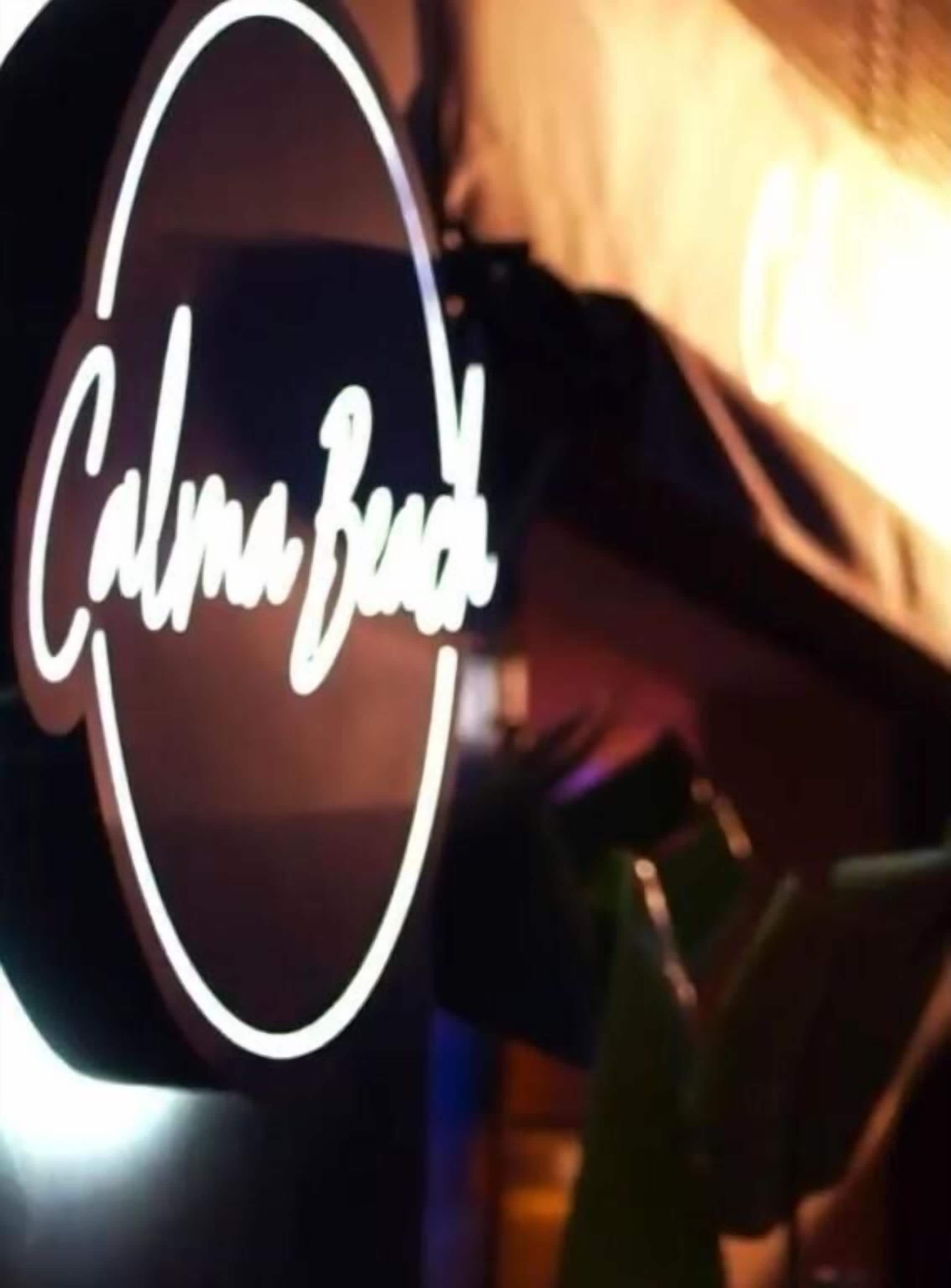 A neon sign with the text "Calm Bed" in a circular design.