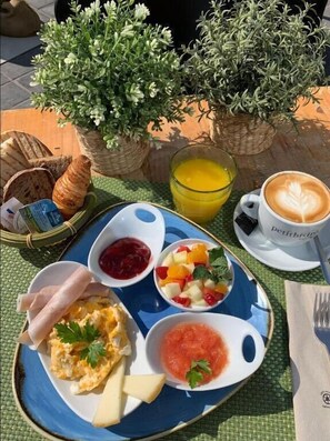 A breakfast setting with croissants, scrambled eggs, fruit, and a cup of coffee on a table with a woven mat. - Valencia Luxury - Calma Beach Apartments (Valencia)